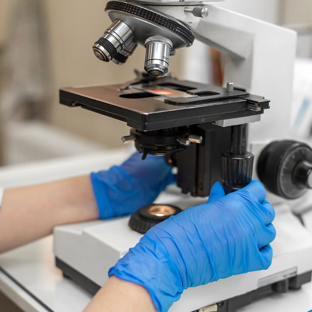 Gateshead Fertility: A doctor positioning a microscope to look at the sperm, egg, or embryo.